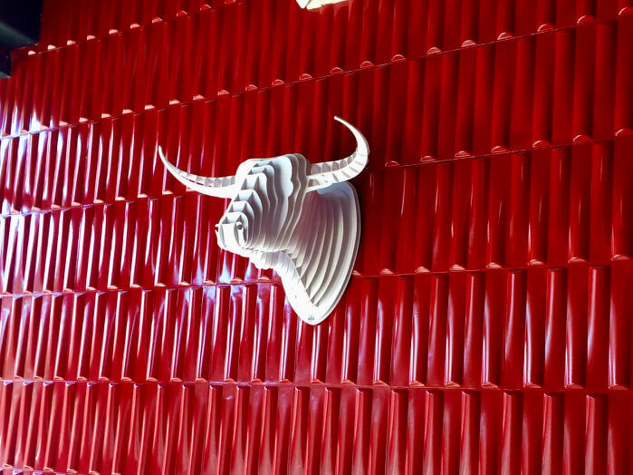 Close up of fake white longhorn against red wall art in Salvation Pizza at Domain Northside in Austin, Texas