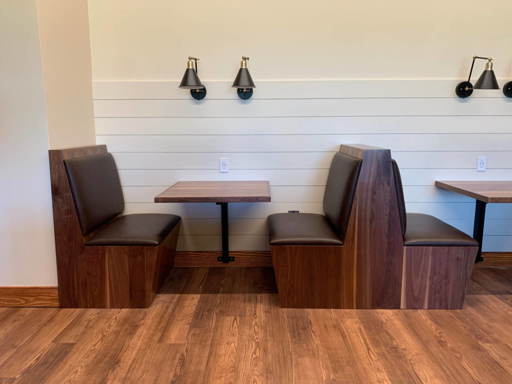 Custom booths with leather upholstery and wood tables in University of Texas Women's Golf lounge