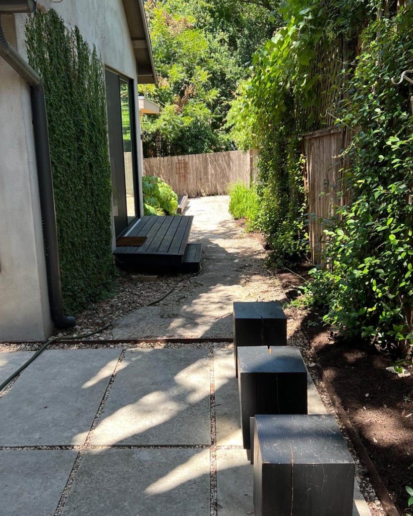 Patio of Bouldin Creek Airbnb in Central Austin, Texas with stools from Round Top, Texas, green with black deck and concrete