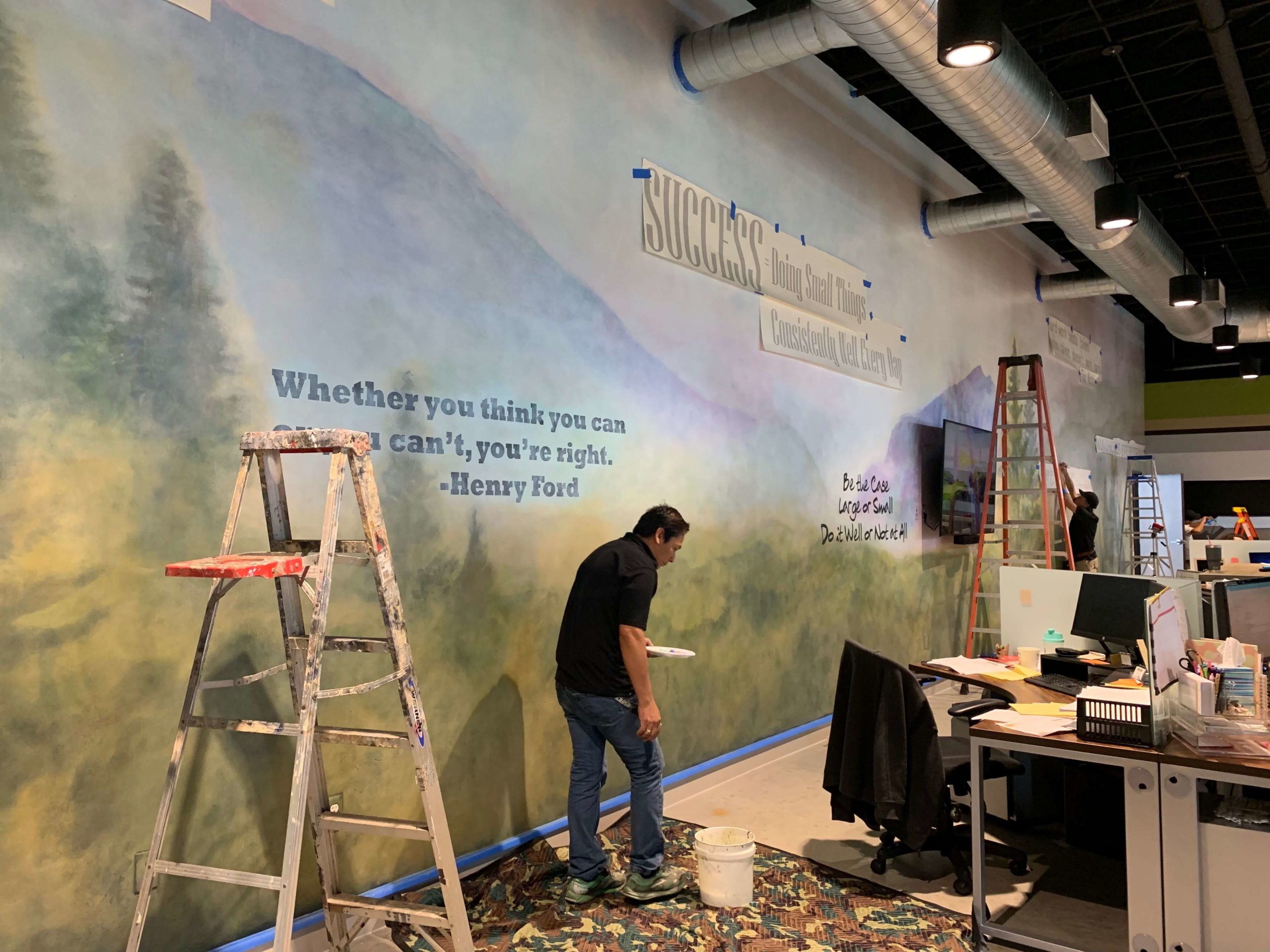 Quotes on pastel mural with mountains and trees in open office space of DC Law Office in North Austin, Texas