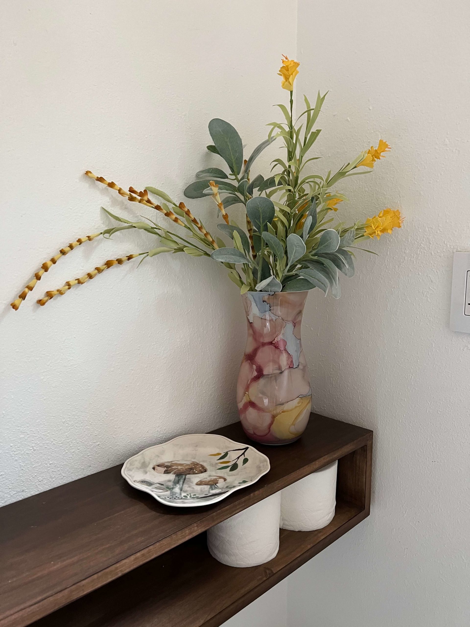 Pink, green, and yellow floral arrangement in bathroom at Bouldin Creek Airbnb in South Austin, Texas